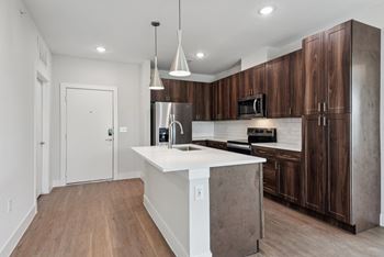 a kitchen with wooden cabinets  at The Virginia, Seguin, Texas